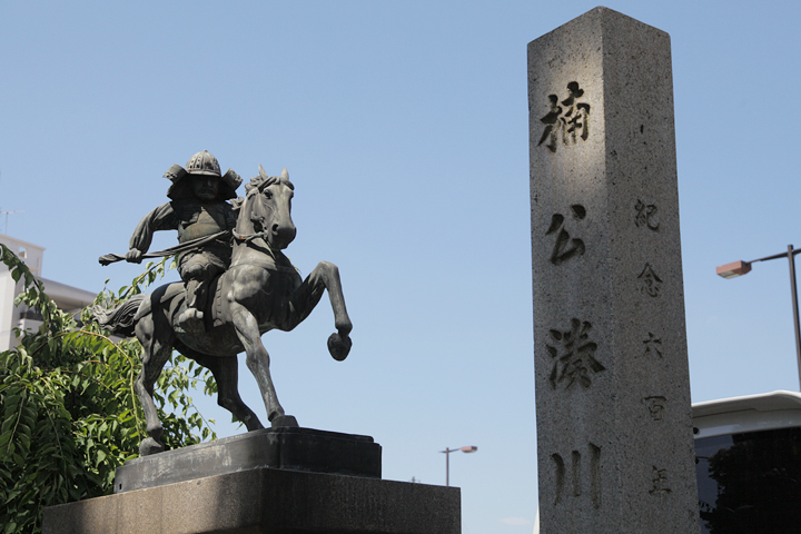 馬に乗った楠木正成と楠公湊川神社の石碑