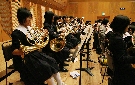 最後列で演奏する金管楽器の学生ら