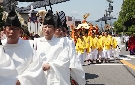 黄色の衣装を着た男達が神輿を運ぶ