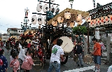 津嶋神社前で鐘と太鼓を打ち鳴らす子供たち